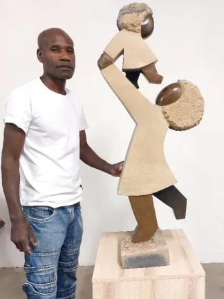 Dominic Benhura with sculpture of woman and child